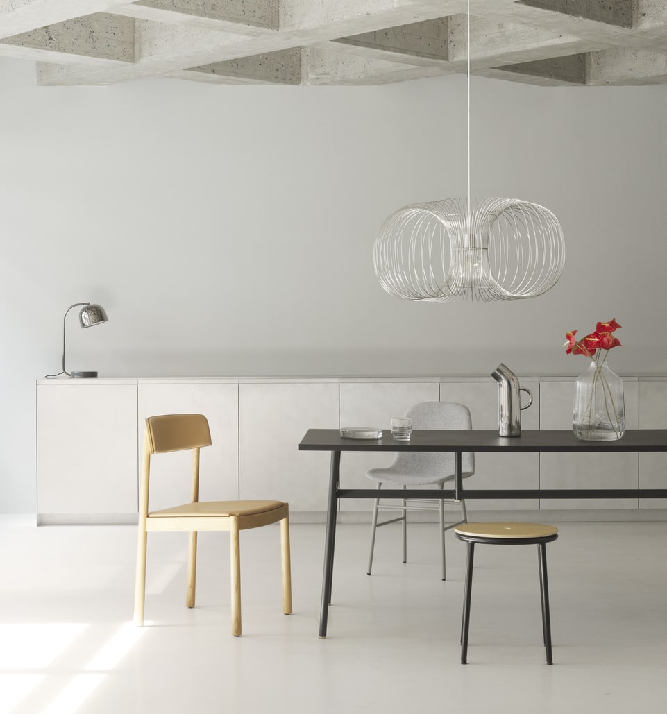 Stor lampe hænger ned fra loft over et spisebord