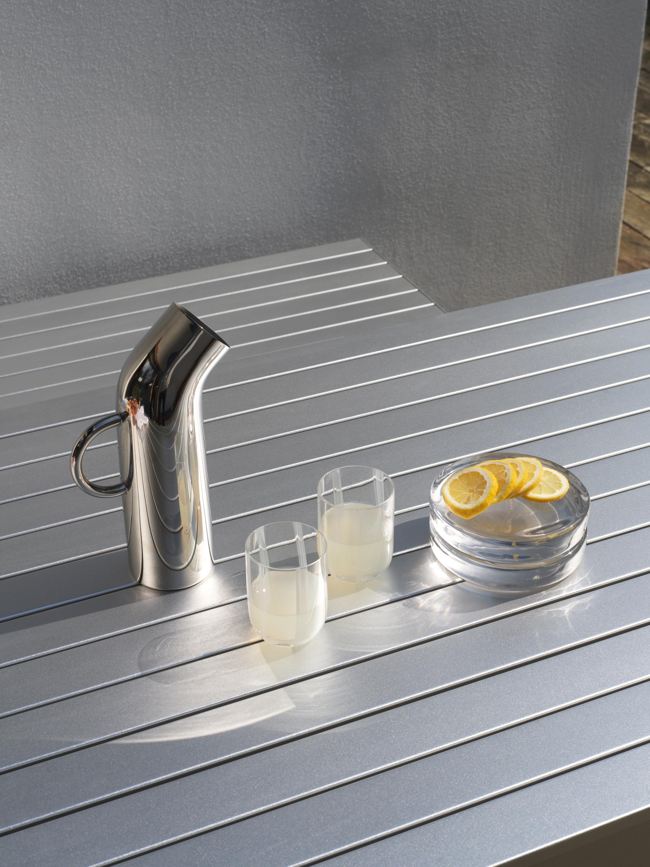 Metal kande på bord med 2 glas og citroner på fad