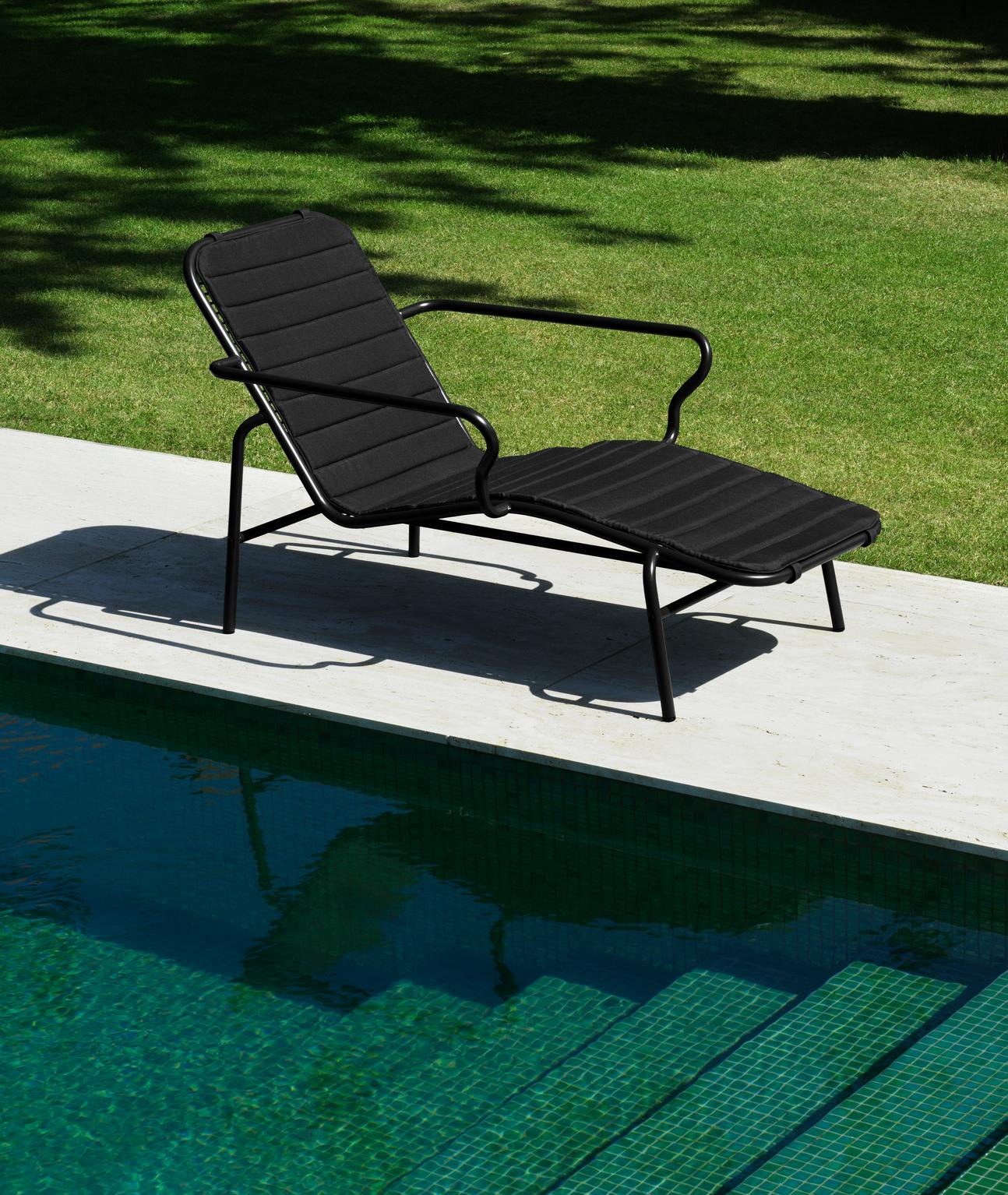 Sort metal liggestol med sort hynde står ved pool