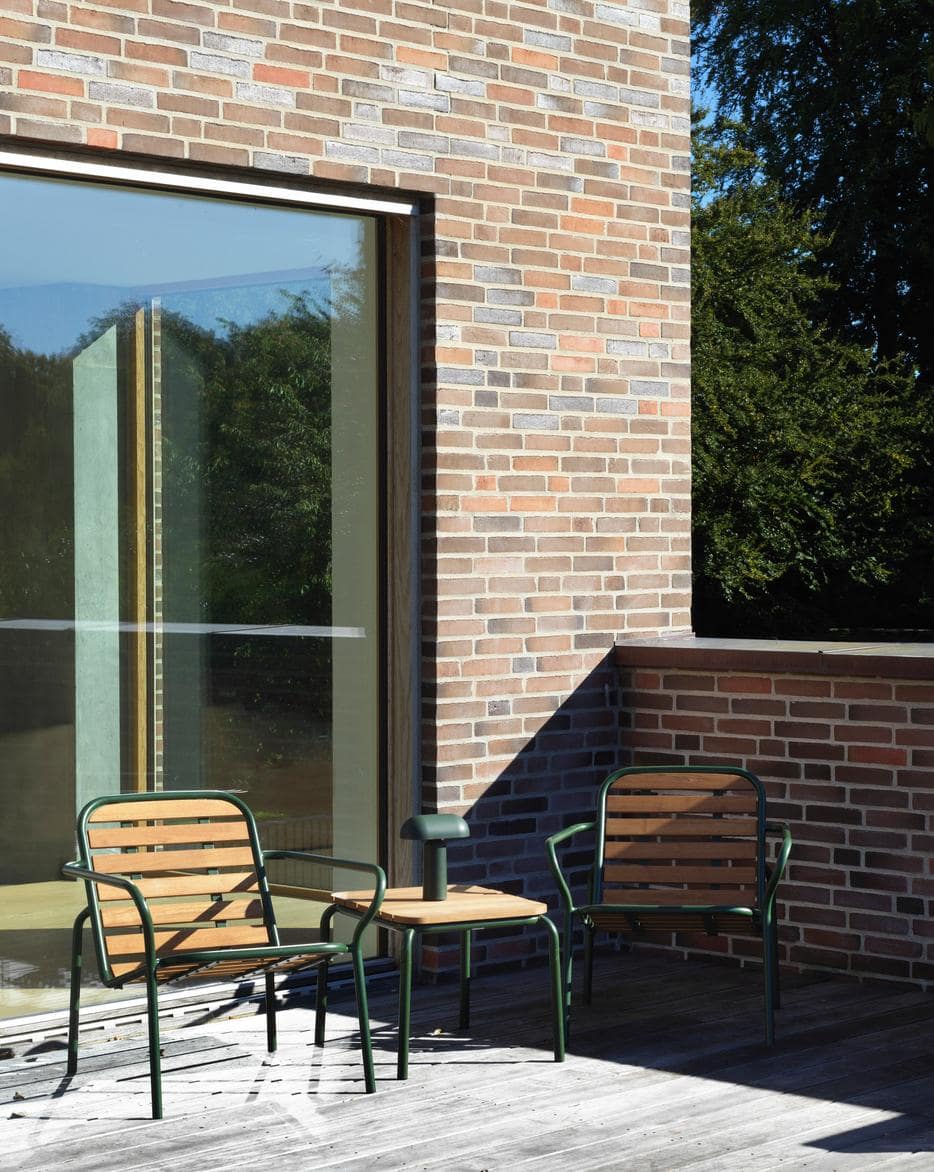 Terrasse med loungesæt i træ og grønt metal stel
