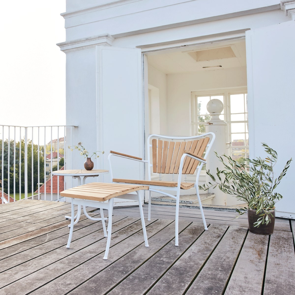 Loungestol med skammel og lille bord på altan