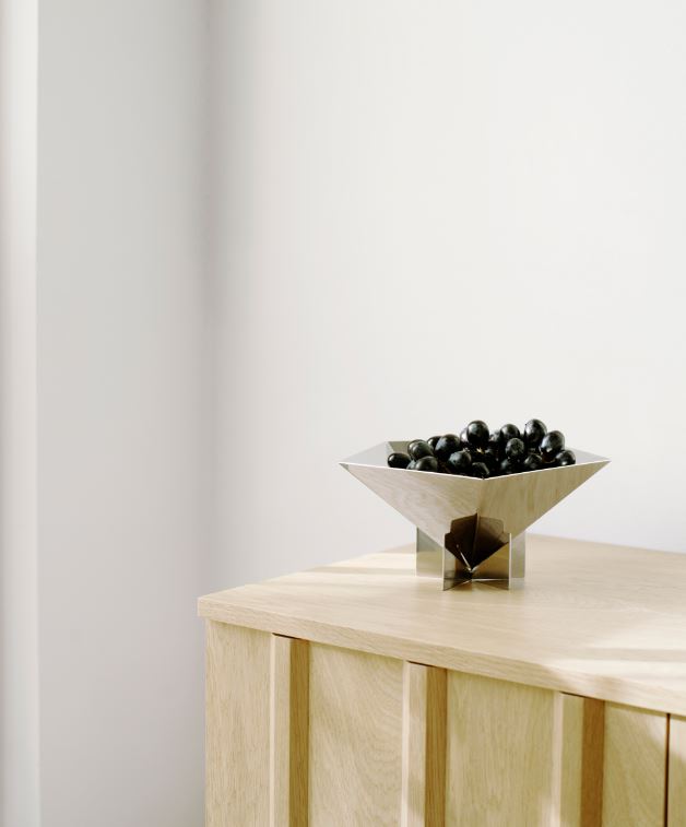 Sølv skål med 5 kanter, stående på kommode.