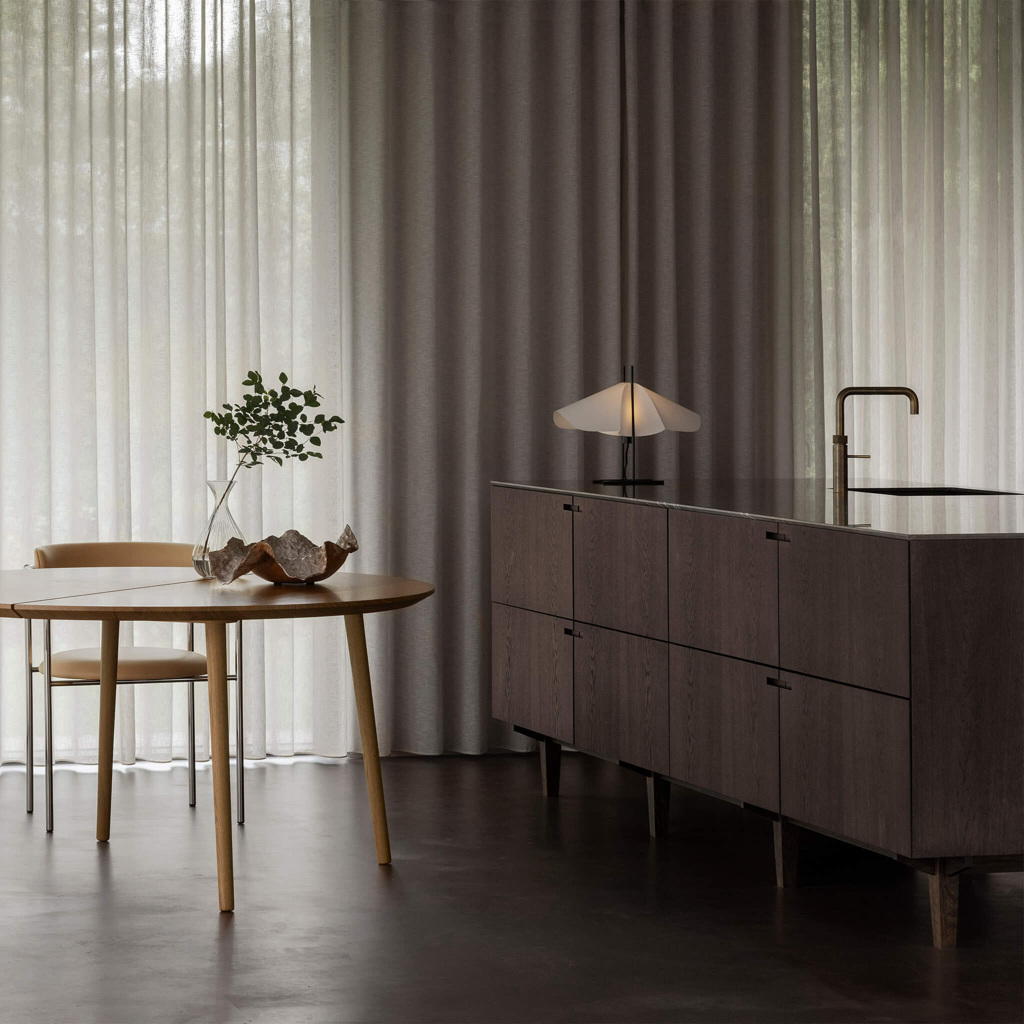 Livsstilsbillede med bordlampe tændt på køkken ø