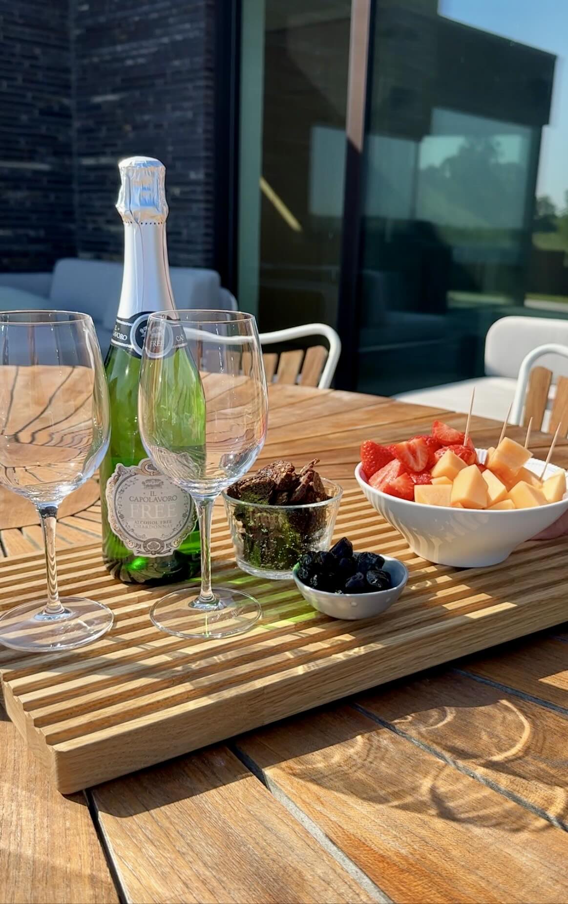 Skærebræt med frugt og vin serveret på