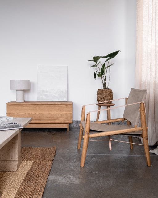 Træstol med siddeplads i beige stof, står i en stue