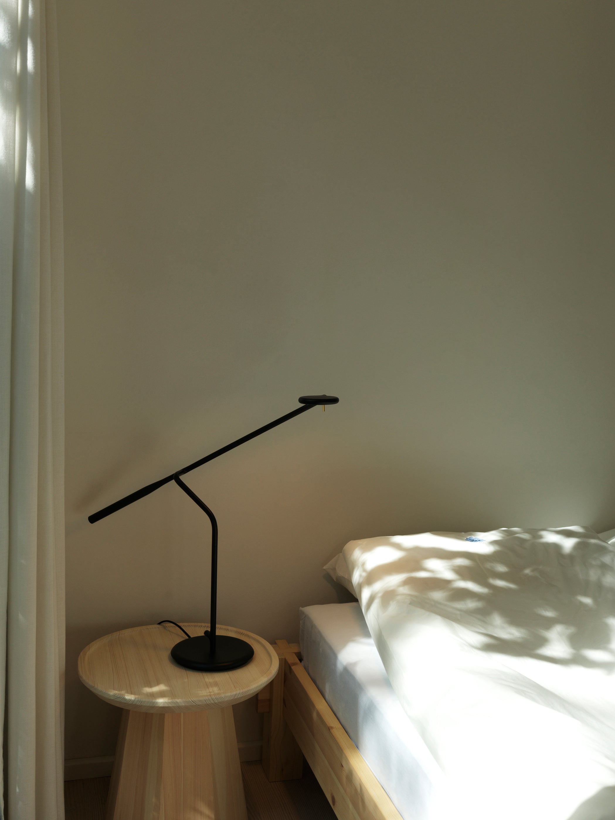 Rund træskammel med sort lampe på