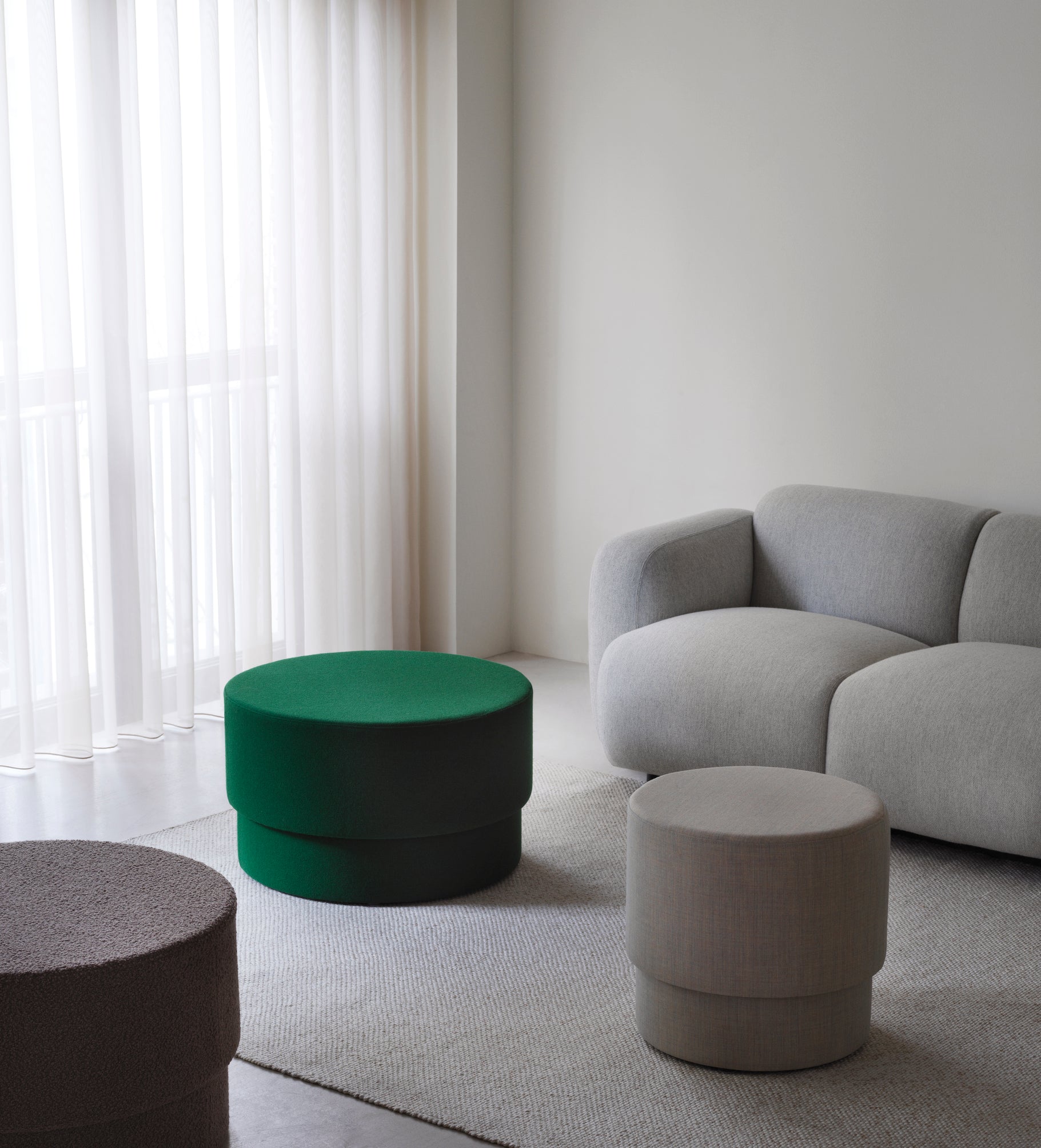Lille grå sofa med 3 puffer i grøn, brun og beige