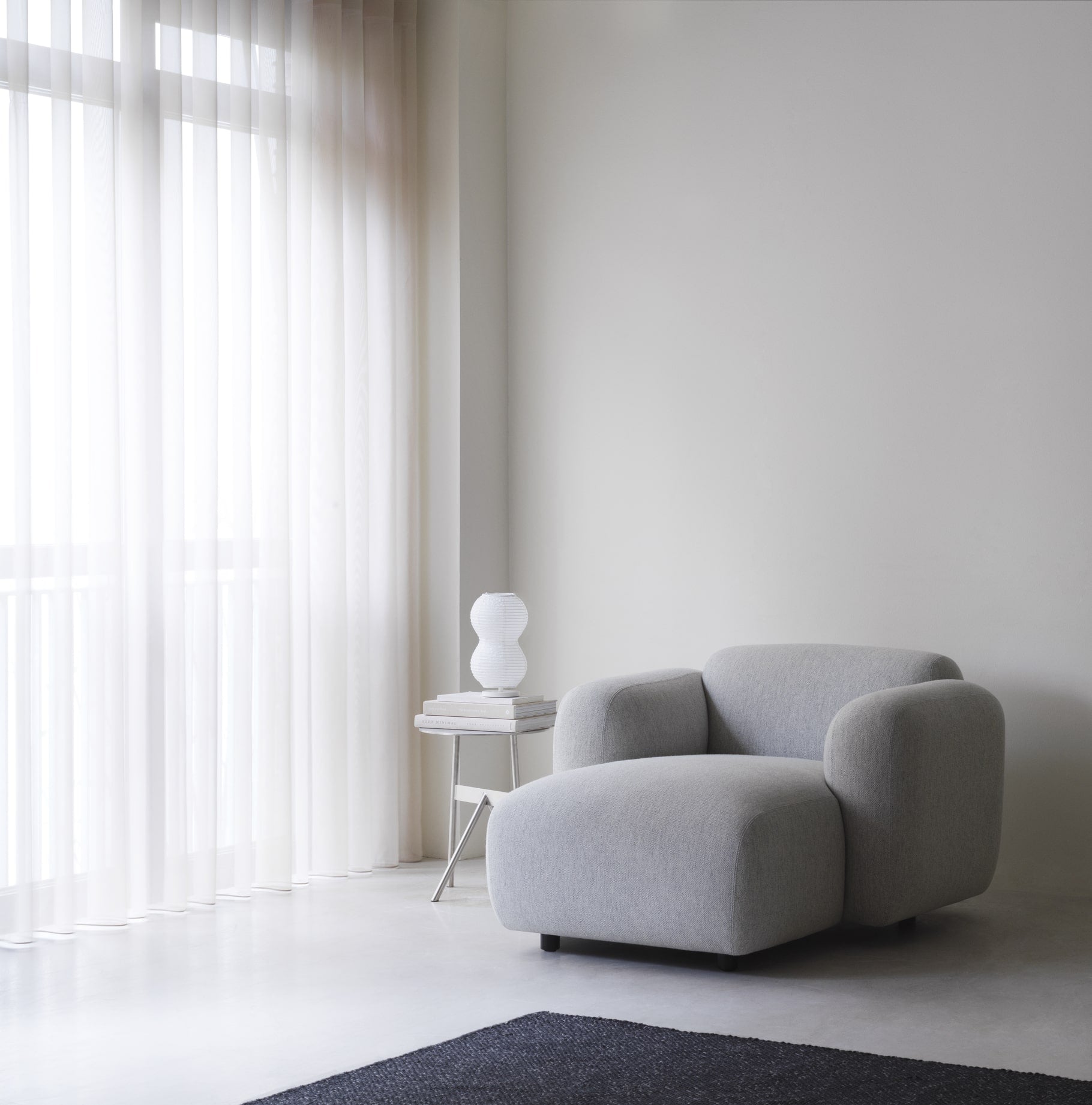 Stor grå lænestol + lille sidebord med lampe