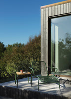 Grøn liggestol med bord i træ og ben i grøn