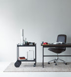 Et sort rullebord med kontorartikler på