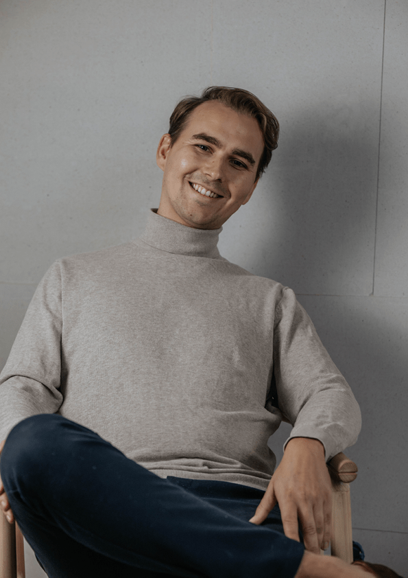 Billede med Emil som sidder på en stol og smiler 