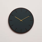 Ur i farven conifer, med mørk træbaggrund og guld viser