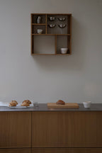 kvadratisk opbevaringsboks i mørkt træ med 5 rum monteret på væg over køkkenbord