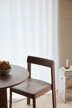 Rundt sofabord og spisebordsstol i mørk træ