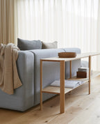 Stue med blå sofa og reol med 2 hylder i eg 