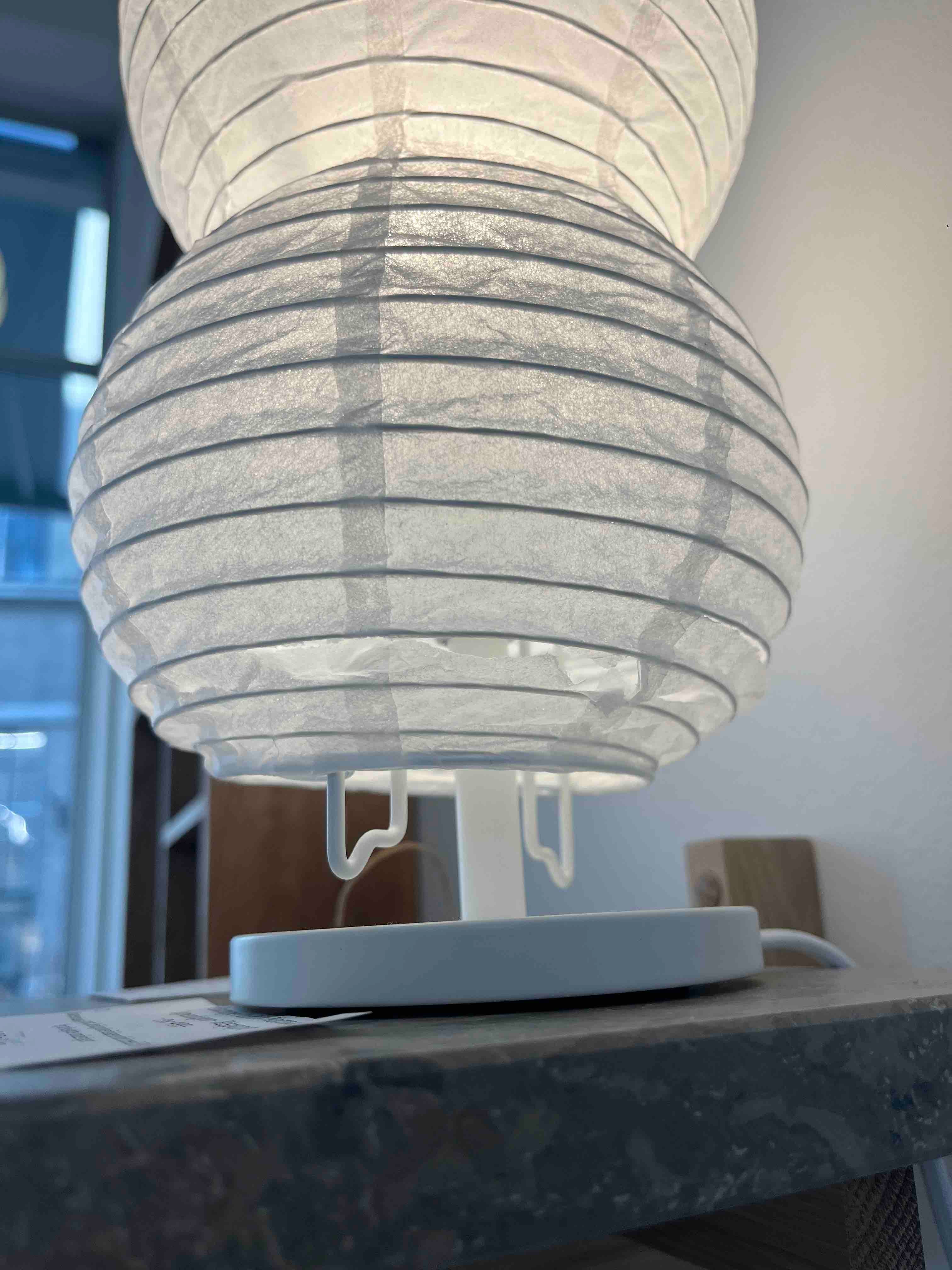 Nærbillede af hvid bordlampe formet som en jordnød