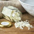 Åben glasbeholder med sæbespåner.