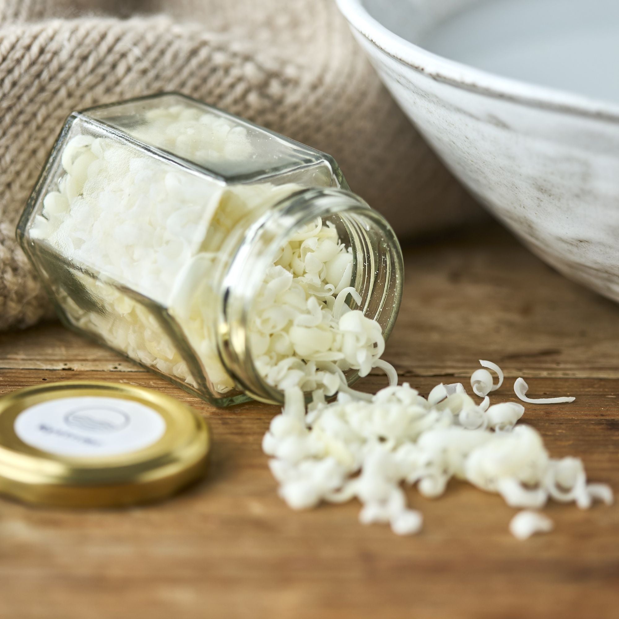 Åben glasbeholder med sæbespåner.