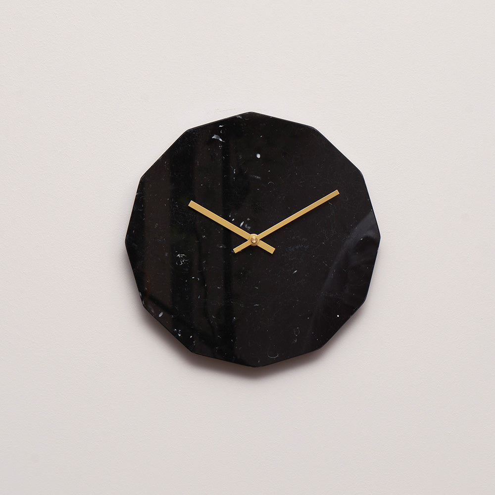 Marmor ur i sort med guld viser 