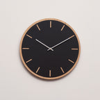 Sort ur med lys træramme med sølv viser 