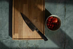Skærebræt med saftrille, med en kniv og en skål med tomater