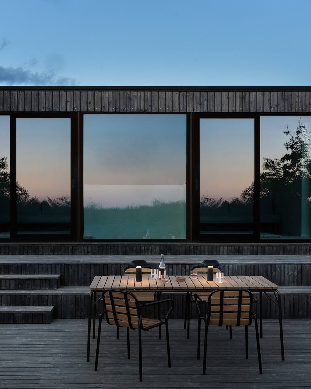 Udenfor på en terrasse med havesæt med træ og sort metal