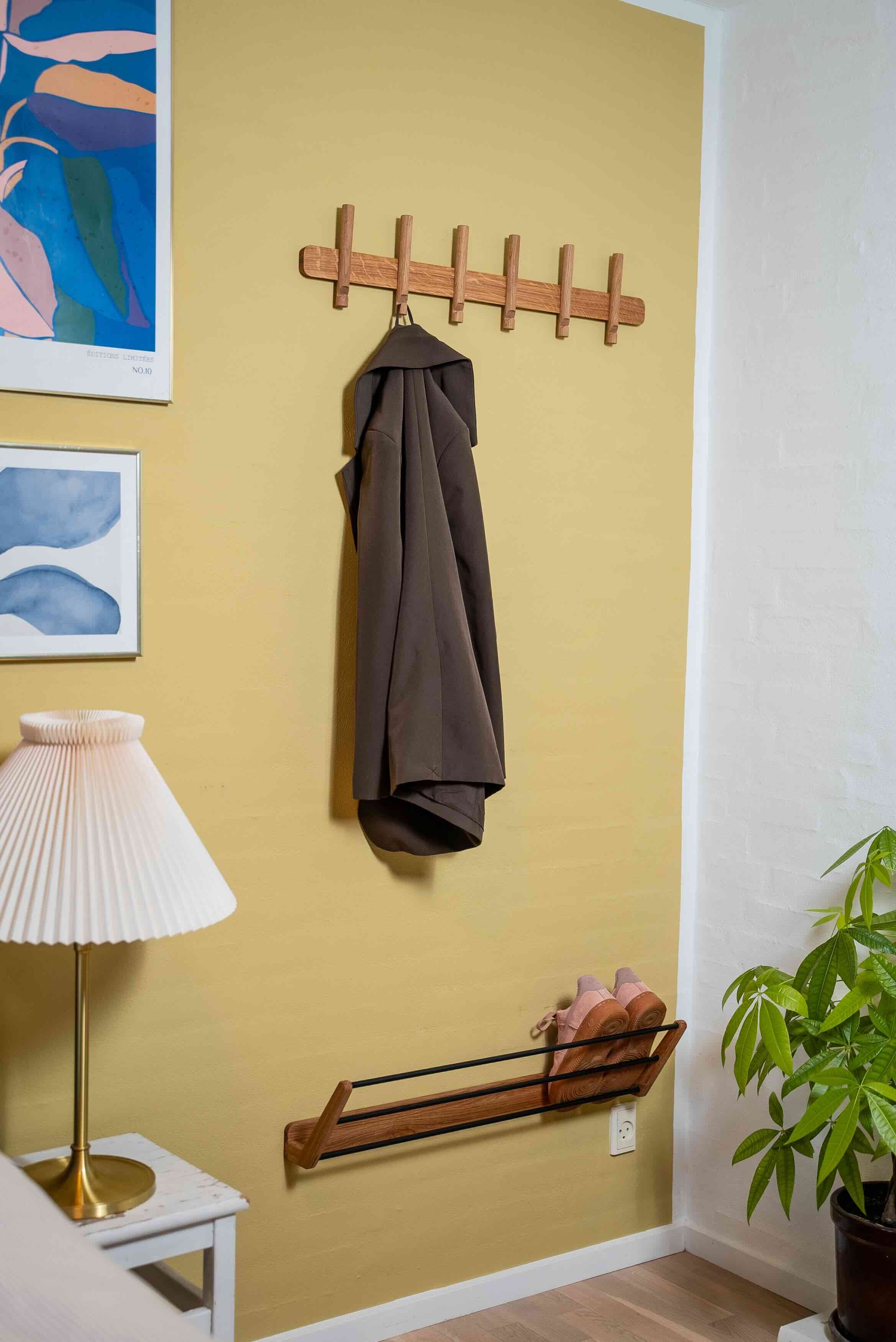 Knagerække i egetræ på en gul væg