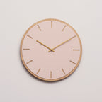 Ur i lyserød med træramme og kobber viser 