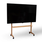 Tv på tv-stander af træ på hjul, med en træhylde. Hvid baggrund. 