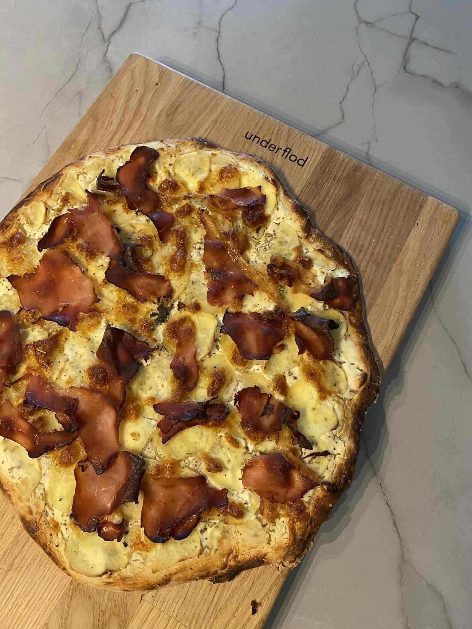 Kartoffelpizza serveret på skærebræt