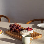 Billede af lille skærebræt med vindruer, brie og skål med hindbær på