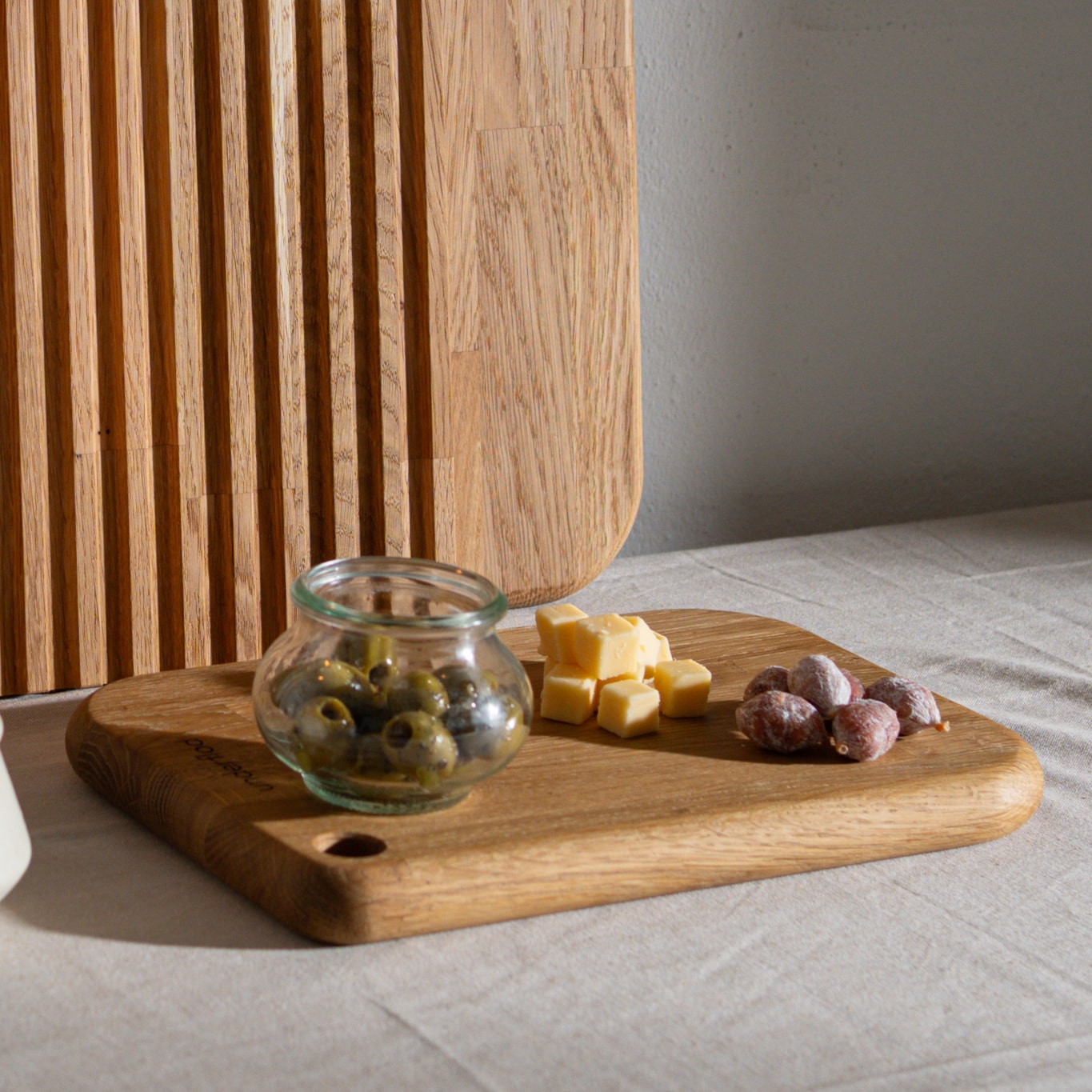 Billede af lille tapasbræt med tapasanretning på med skærebræt i baggrunden