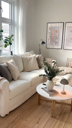 Stue med hvid sofa og rundt spisebord i marmor