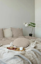 Seng med sengetøj og puder i brune nuancer