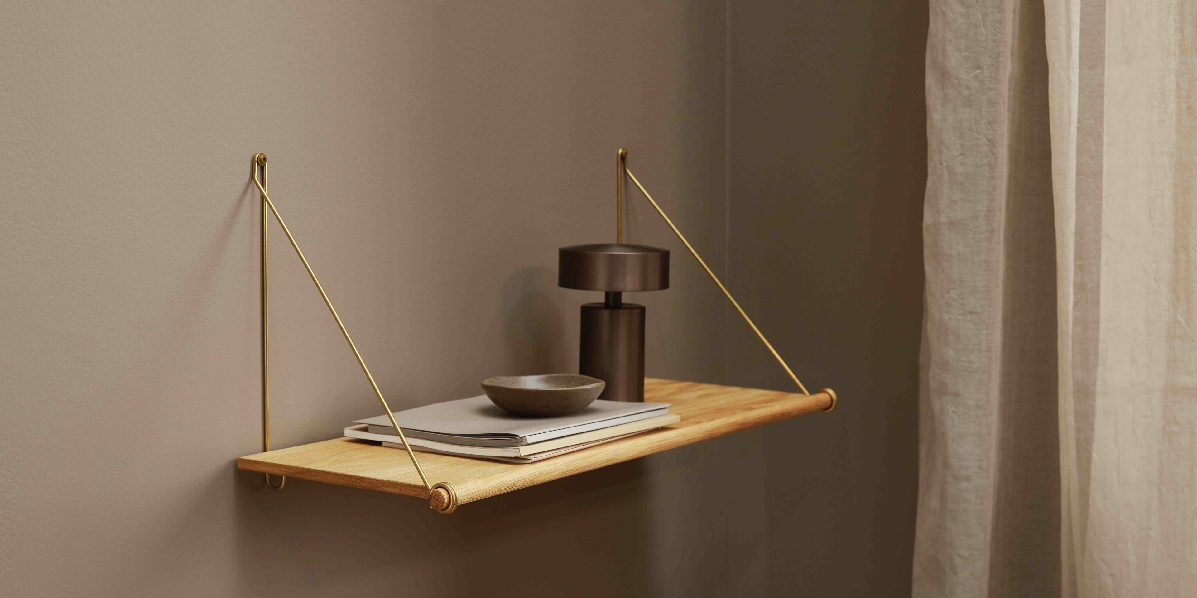 Hylde med lampe og magasiner på