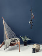 Livsstils billede med en stol, vaser og en knage hængende fra loftet med interiør på.