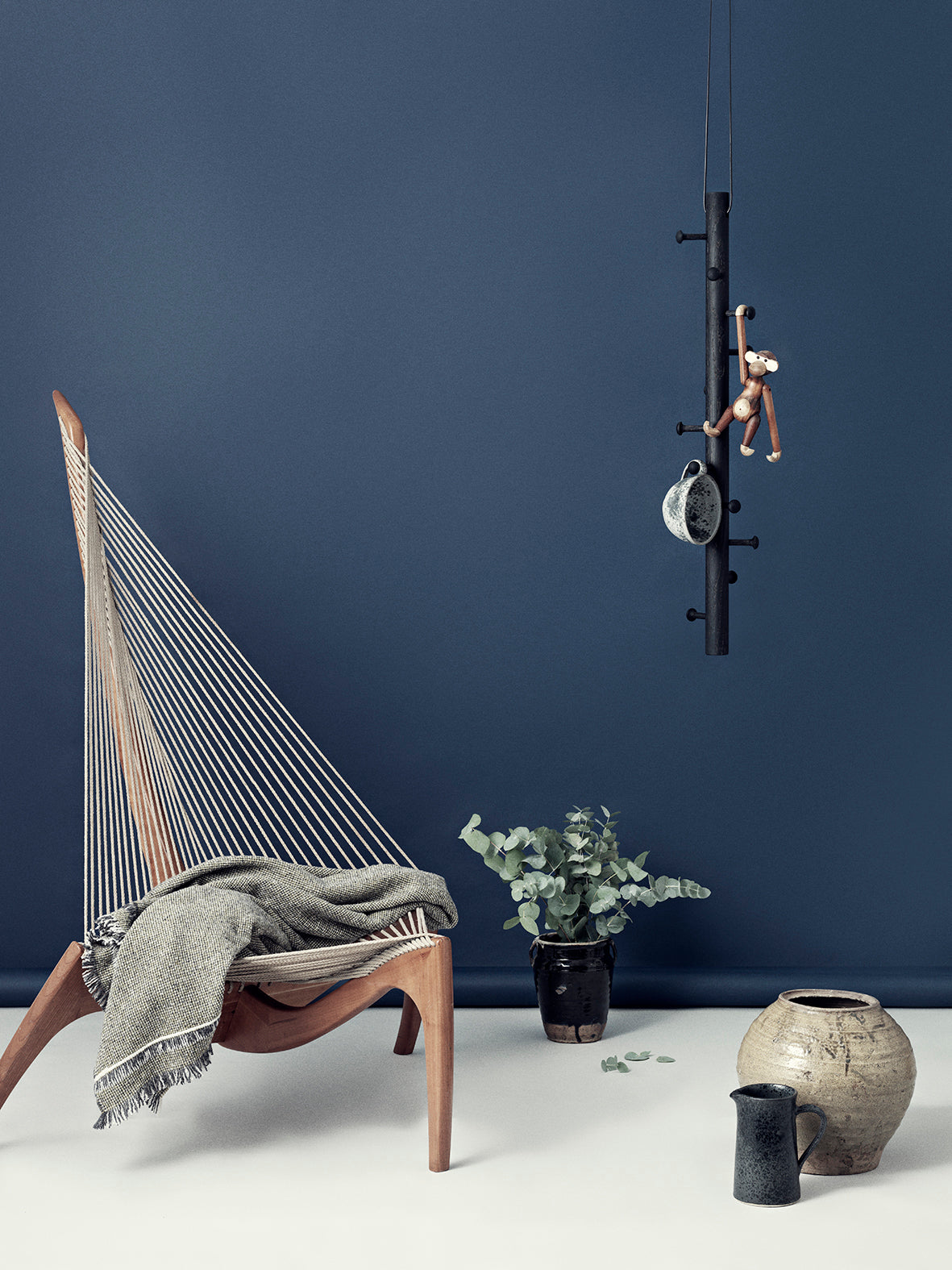 Livsstils billede med en stol, vaser og en knage hængende fra loftet med interiør på.