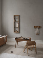 Børneværelse med skrivebord og stol til børn. Derudover er der også en foursquare hylde, knagerække og en opbevarings bænk