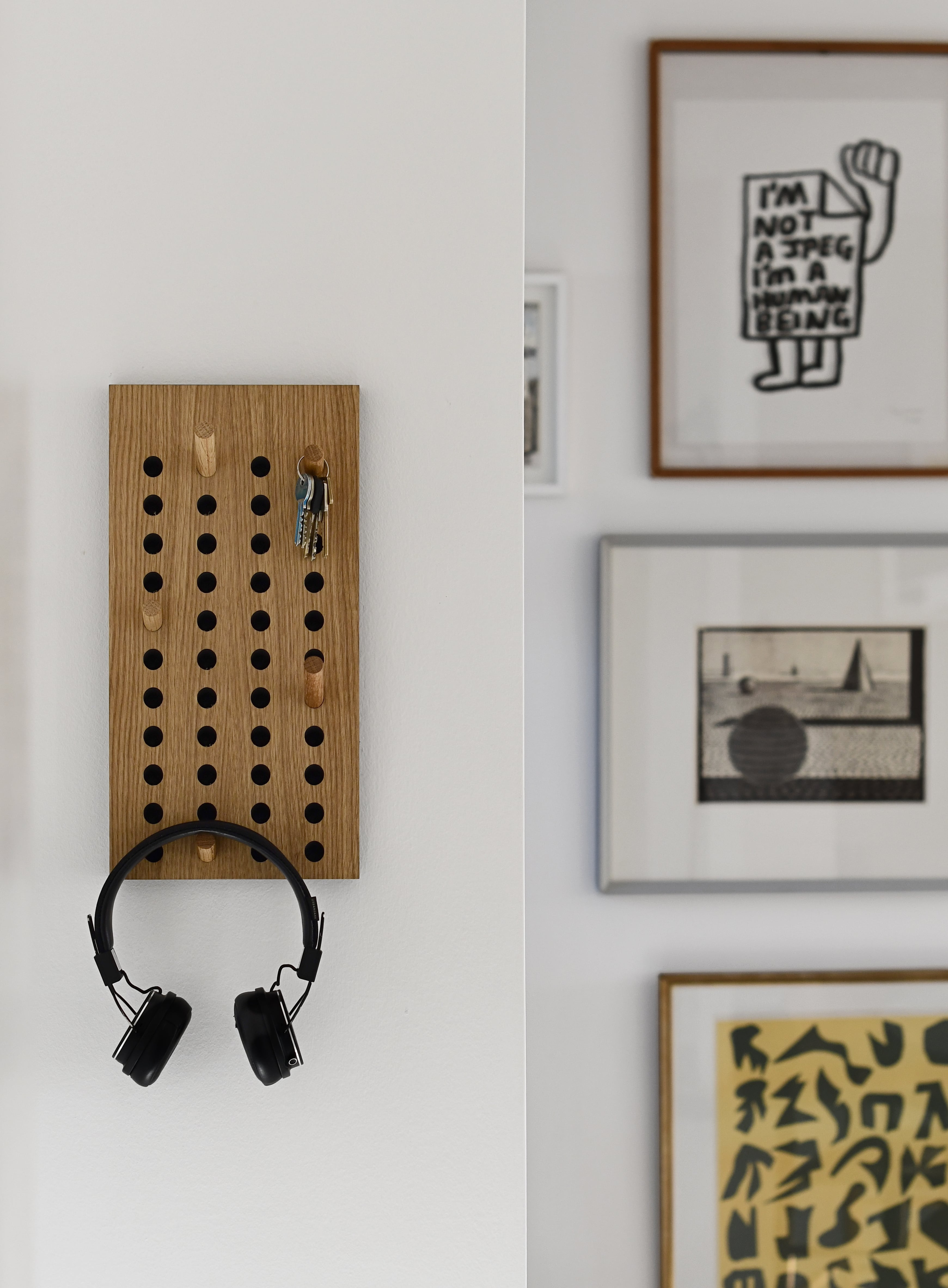 Lille scorboard knagerække på en væg, hvor der hænger nøgler og hovedtelefoner på.