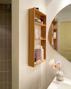 Reol med 3 hylder i træ, på badeværelse med cremer