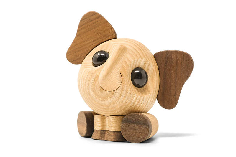 En træfigur af en elefant med mørke ører og fødder, samt glatte øjne. 