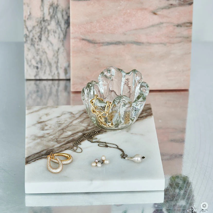 Glasskål med guldsmykker i