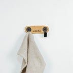 viskestykkeholder med to kroge med ét viskestykke hængende på