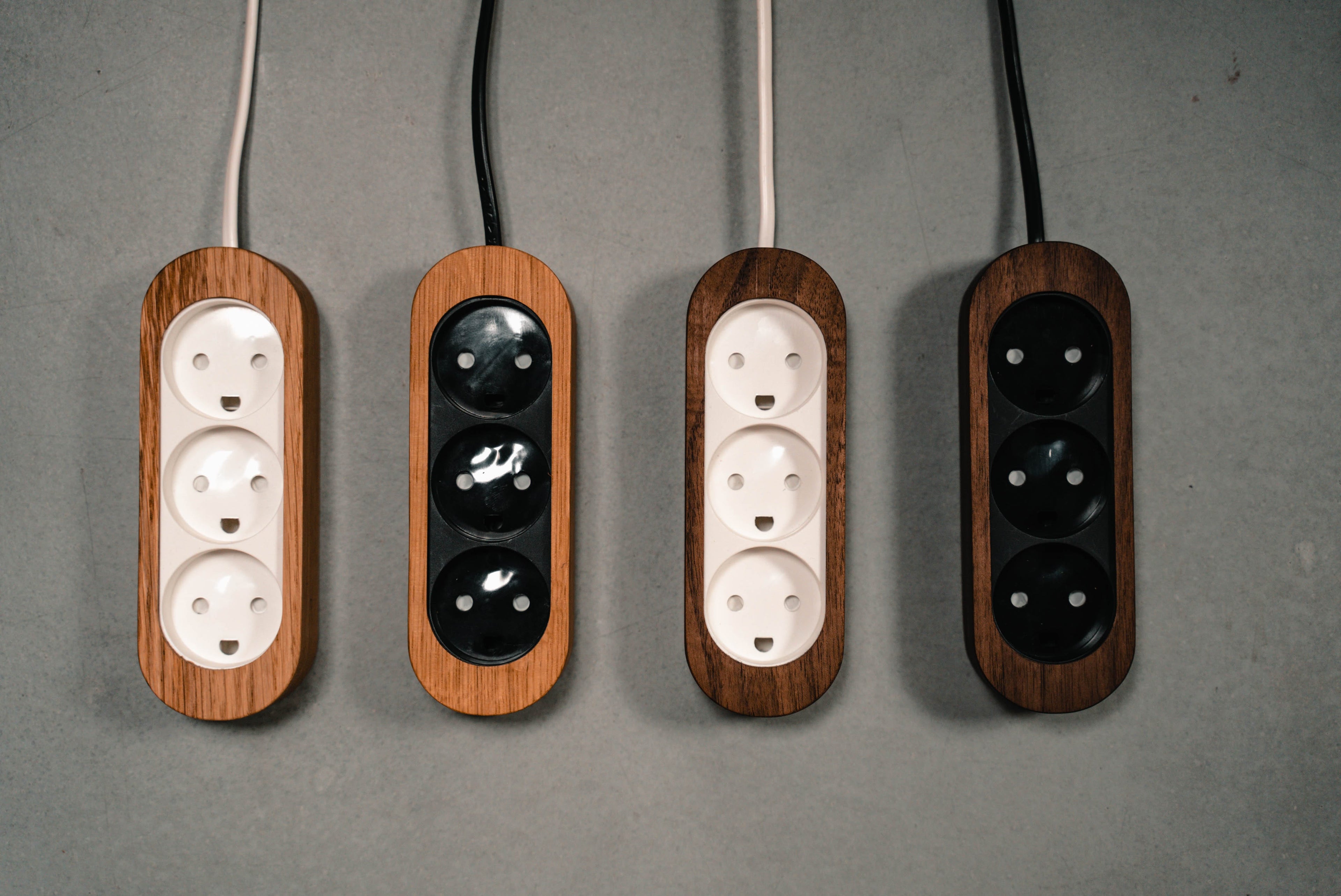 Billede af 4 stikdåser i forskellige muligheder - hvid og egetræ, sort og egetræ, hvid og valnød, sort og valnød 